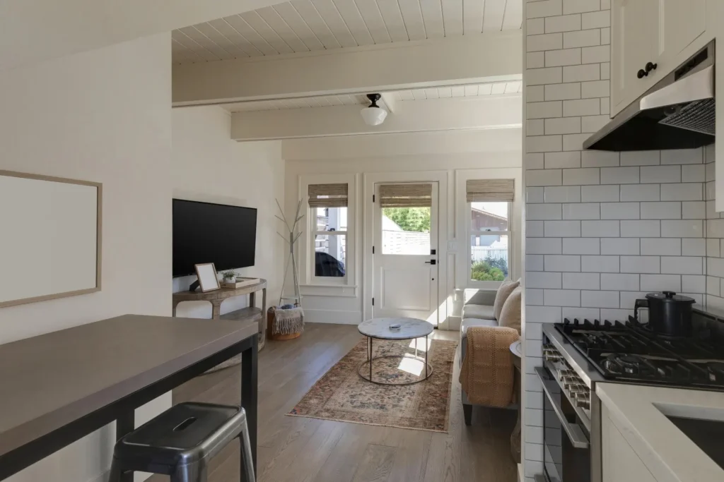 Traditional cottage interior with a sectional and an adjacent kitchen, after a home remodel