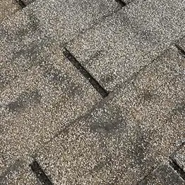 closeup of roof shingles with dark streaks