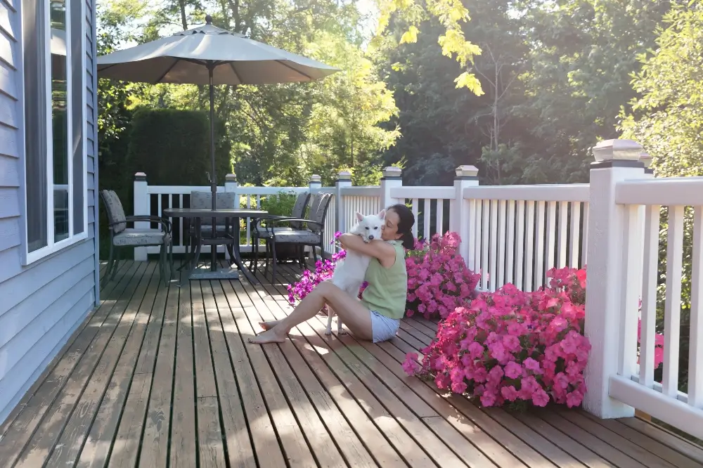 pet mom and dog sitting on a newly installed deck - Dagmar Construction