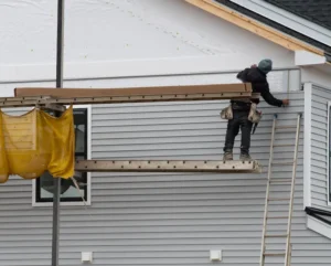 A Dagmar Pros team member installing gray fiber cement siding on a Vancouver WA home.